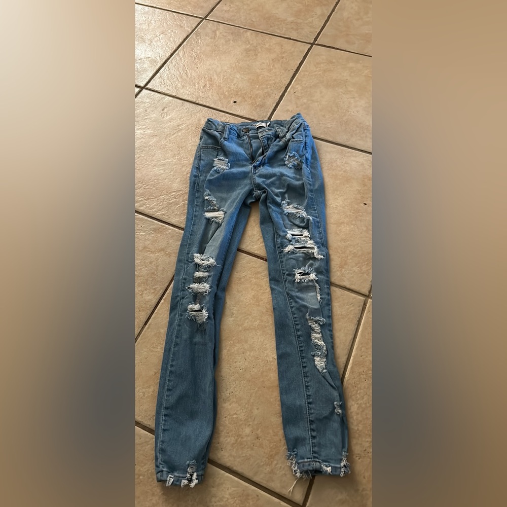 These are a pair of rue21 skinny jeans with holes in the front with patches